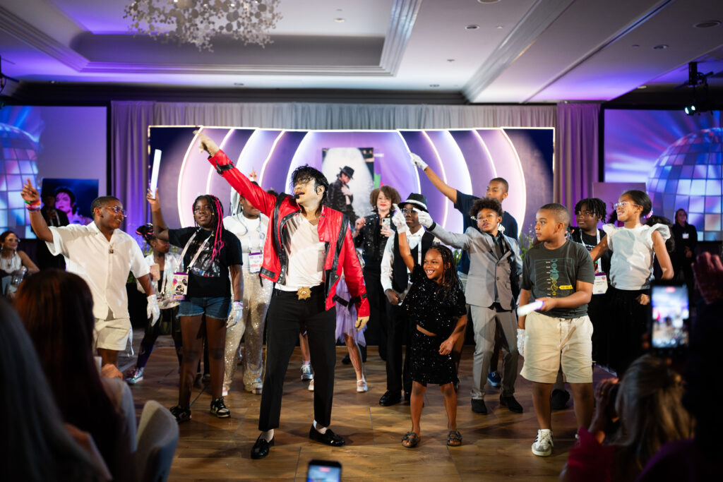 A Michael Jackson impersonator dances with a group of children