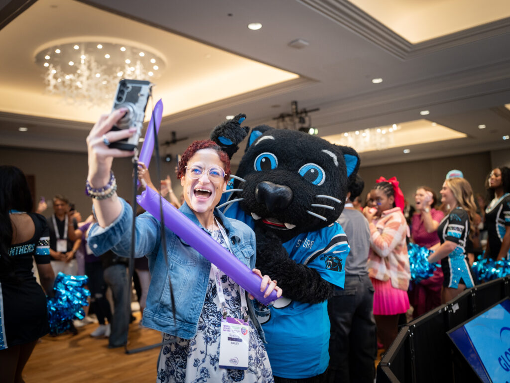 A women with vitiligo takes a selfie with Sir Purr, the Carolina Panthers mascot