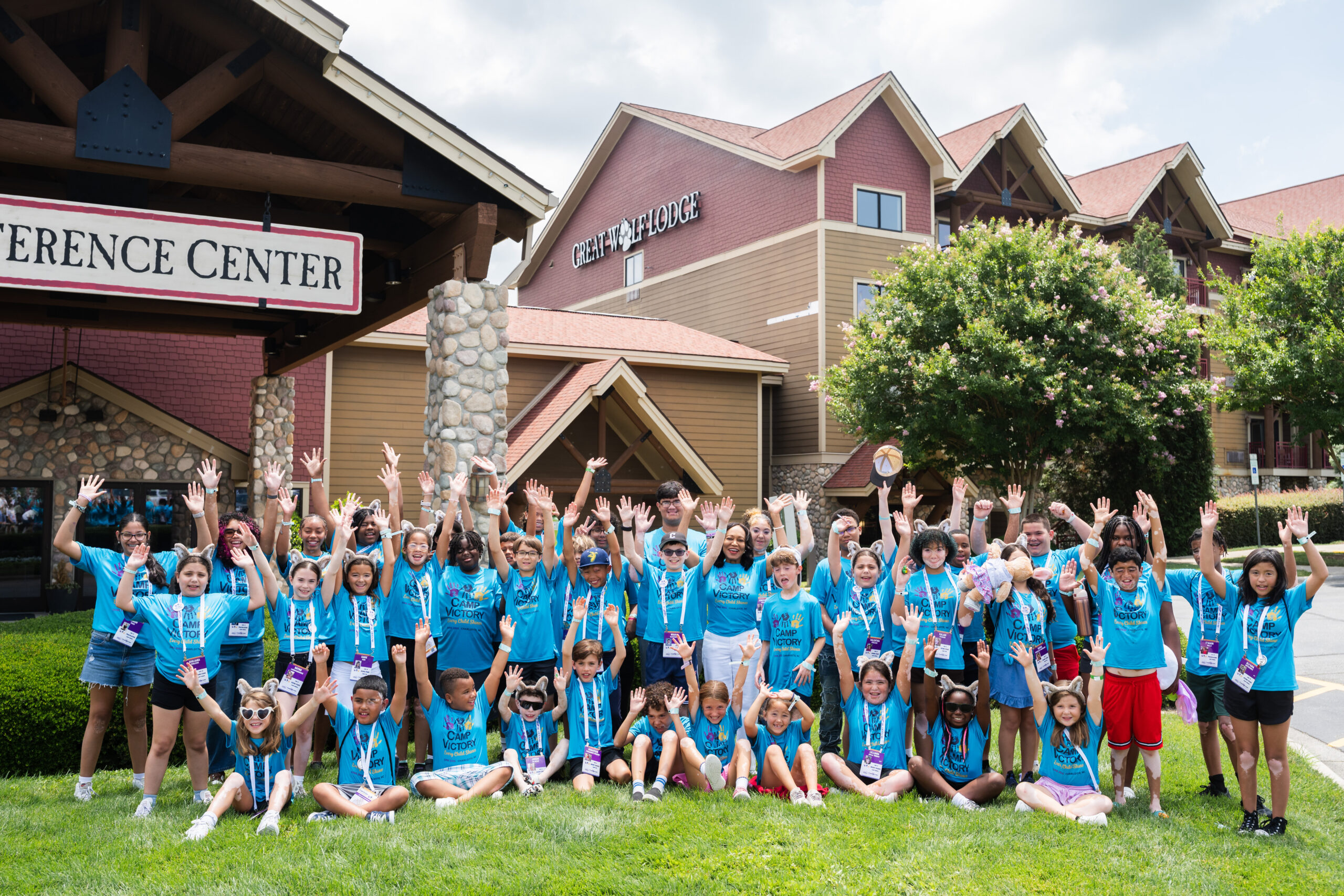 Group of children posing with arms raised in front of Great Wolf Lodge
