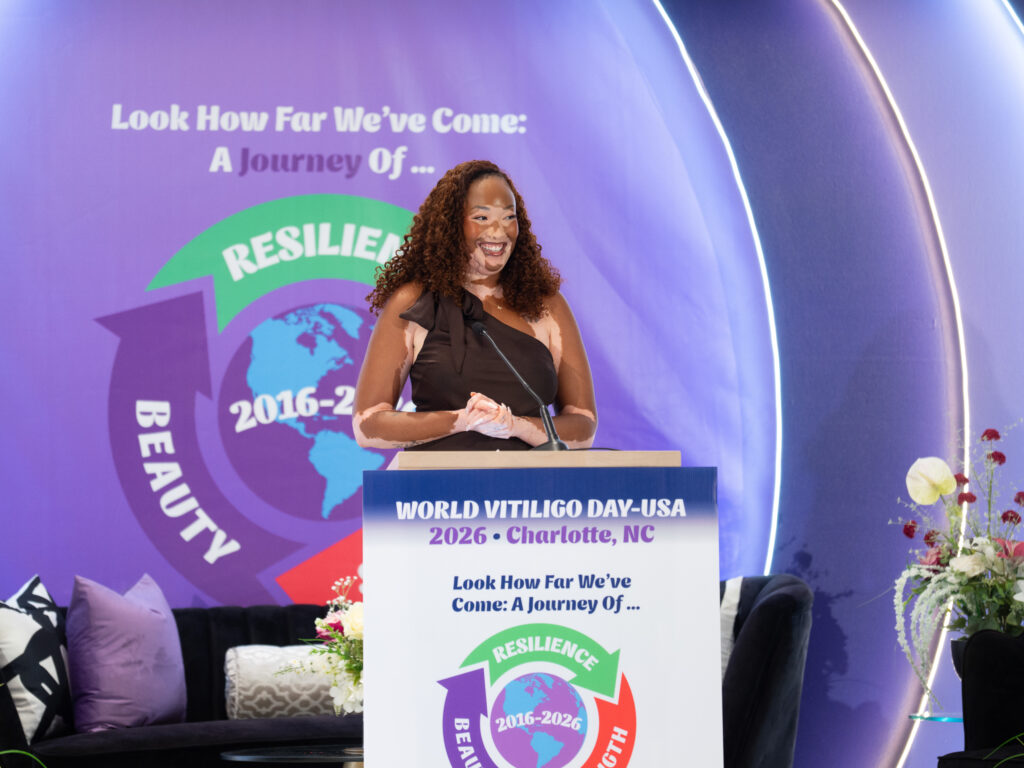 A women with vitiligo stands at a podium